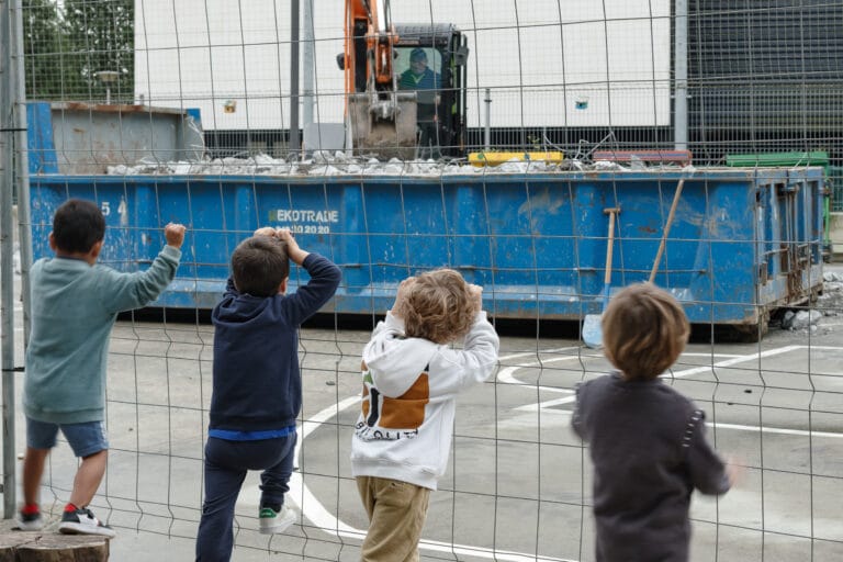 niños viendo una obra en un patio escolar
